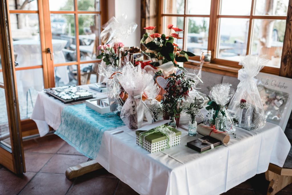 Hochzeitsgeschenke und Blumen auf einem dekorierten Tisch in der Mostschenke