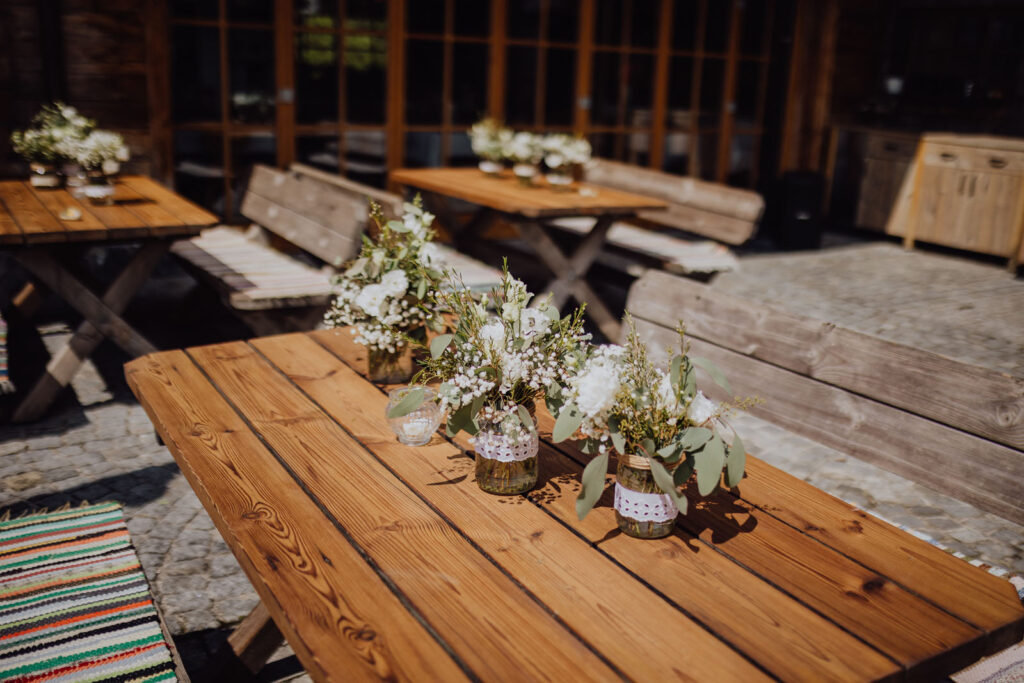 Liebevoll mit Blumen dekorierte Hochzeitstische beim Hussenbauer