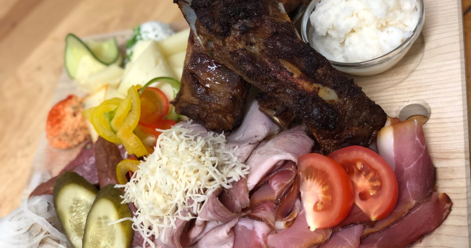 Brettljause mit knusprigen Ripperln, Schinken, Käse, Kren und frischem Gemüse